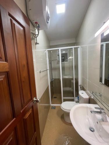 uma casa de banho com um chuveiro, um WC e um lavatório. em Wellawatte Apartments em Colombo