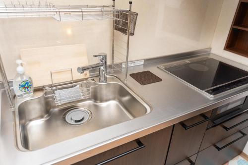 a stainless steel sink in a small kitchen at OneWorld Mibu壬生Luxury京町家 in Kyoto