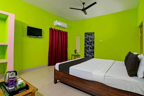 Khushi Guest House في بوهفانيشفار: غرفة نوم بجدران خضراء وسرير في غرفة