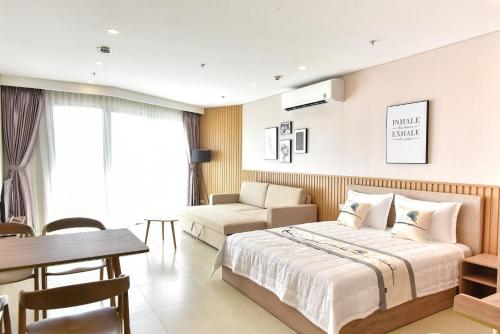 a bedroom with a bed and a table and a chair at Condotel The Sóng Vung Tau in Vung Tau