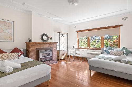 a living room with two beds and a fireplace at Cozy Lindfield Stayz in Sydney