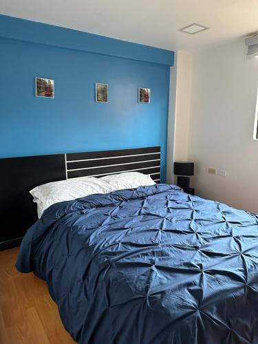 1 dormitorio azul con 1 cama con pared azul en C&L Apartment, en Cuenca