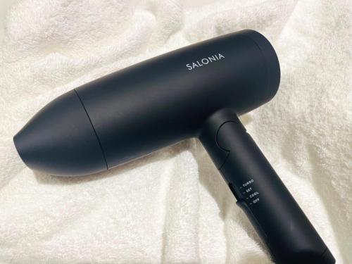 a black hair dryer sitting on a blanket at Mars Garden Hotel Hakata in Fukuoka