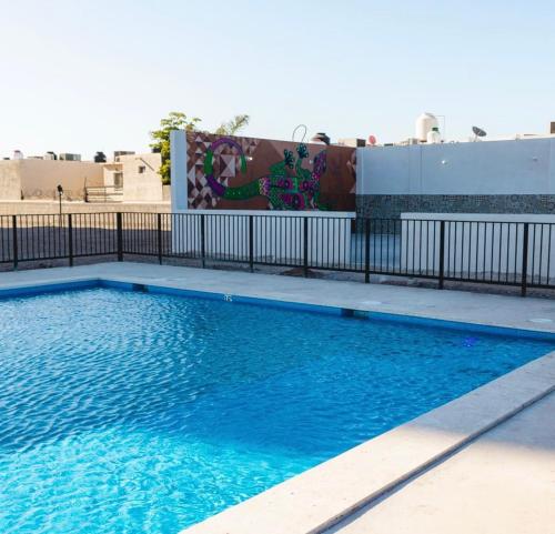 una piscina con valla y agua azul en Edificio nuevo, en Hermosillo
