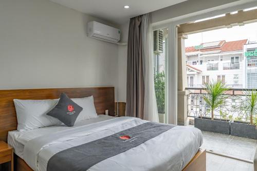 ein Schlafzimmer mit einem Bett und einem großen Fenster in der Unterkunft Edoya Hotel Phu My Hung in Ho-Chi-Minh-Stadt