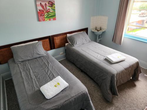 een slaapkamer met 2 bedden en een raam bij The Exchange Hotel in Kyogle