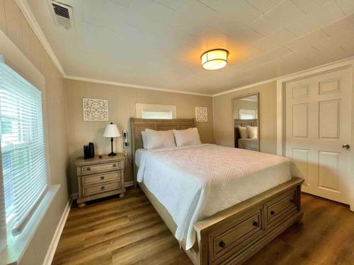 een slaapkamer met een groot bed en een spiegel bij Relax in Privacy in 2BR Beauty w/ Fire Pit & Grill in Greensboro