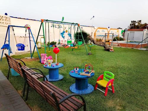 a playground with a table and chairs and swings at Mis Princesas en casa in Chiclana de la Frontera