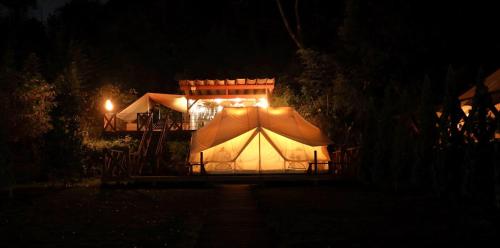 uma tenda é iluminada no escuro à noite em THE FARM Resort Japan em Katori