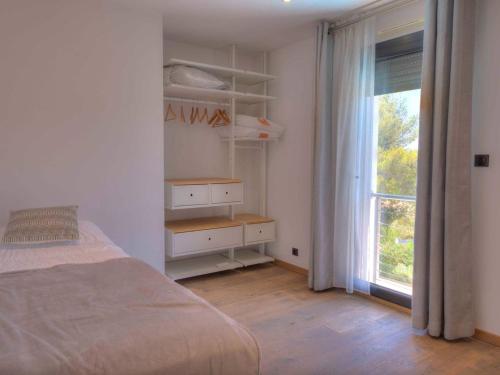 une chambre blanche avec un lit et une fenêtre dans l'établissement Villa Familiale avec Piscine, 4 Chambres, BBQ et Clim à La Cadière-d'Azur - FR-1-770-21, à Laouque