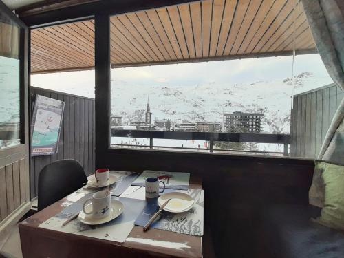 - une table dans une chambre avec vue sur la montagne dans l'établissement Studio Rénové 3p · Pied des Pistes · Balcon Sud/Ouest · 3 Flocons Or - FR-1-344-1206, aux Menuires