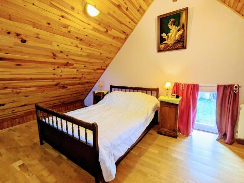 ein Schlafzimmer mit einem Bett und einer Holzdecke in der Unterkunft Gîte Saint-Hilaire-sur-Benaize, 2 pièces, 3 personnes - FR-1-591-575 in Saint-Hilaire-sur-Bénaize