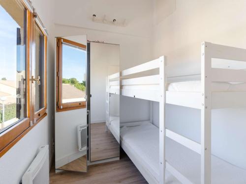 Cette chambre dispose de lits superposés et d'une fenêtre. dans l'établissement Pavillon T3 avec piscine, climatisation et parking à Narbonne-Plage - FR-1-409-248, à Narbonne