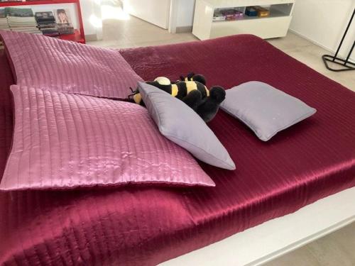 - un ours en peluche posé sur un lit avec des oreillers dans l'établissement Charmant 2P climatisé avec terrasse et jardin, centre-ville Le Lavandou - FR-1-308-187, au Lavandou