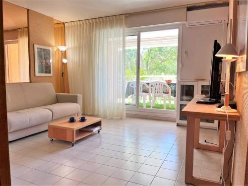 un salon avec un canapé et une table dans l'établissement Appartement cosy à Cavalière avec terrasse, proche plage et commerces, 6 couchages - FR-1-251-546, au Lavandou