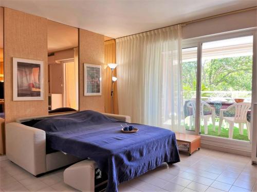 a bedroom with a blue bed and a balcony at Appartement Le Lavandou, 2 pièces, 6 personnes - FR-1-251-546 in Le Lavandou