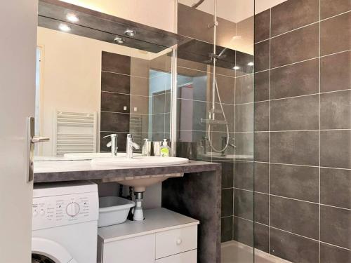 une salle de bain avec un lavabo et une machine à laver dans l'établissement Appartement cosy à Cavalière avec terrasse, proche plage et commerces, 6 couchages - FR-1-251-546, au Lavandou