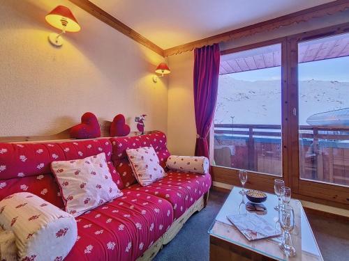 a living room with a red couch and a table at Grand appartement 3 pièces · Pied des pistes · Balcon · Wifi - FR-1-344-1205 in Les Bruyères