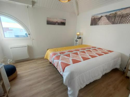 une chambre avec un lit et une fenêtre dans l'établissement Duplex confortable au cadre verdoyant avec piscine, proche du golf - FR-1-323-493, à Saint-Jean-de-Monts