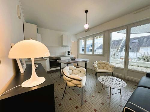 un salon avec une table et des chaises et une cuisine dans l'établissement Fouesnant, 50m plage Cap Coz, app. cosy 2 pers, terrasse, parking - FR-1-481-154, à Fouesnant
