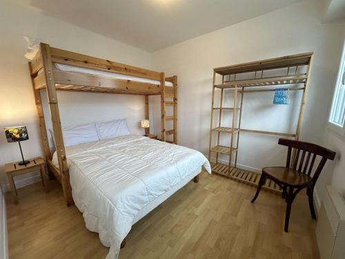 - une chambre avec 2 lits superposés et une chaise dans l'établissement Fouesnant, 50m plage Cap Coz, app. cosy 2 pers, terrasse, parking - FR-1-481-154, à Fouesnant