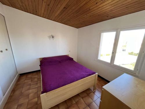 ein kleines Schlafzimmer mit einem lila Bett darin in der Unterkunft Appartement Marseillan-Plage, 2 pièces, 6 personnes - FR-1-387-201 in Marseillan