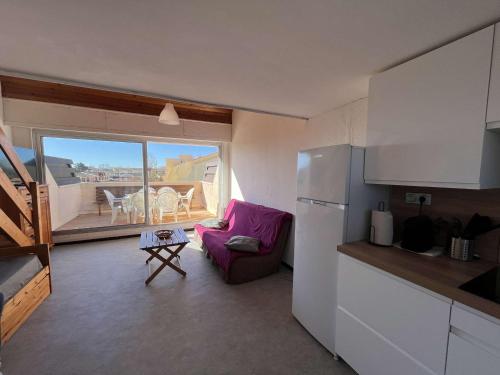 Il comprend une cuisine avec une chaise violette et un balcon. dans l'établissement Duplex central avec terrasse, parking et équipements modernes pour 6 personnes à Marseillan - FR-1-387-201, à Marseillan