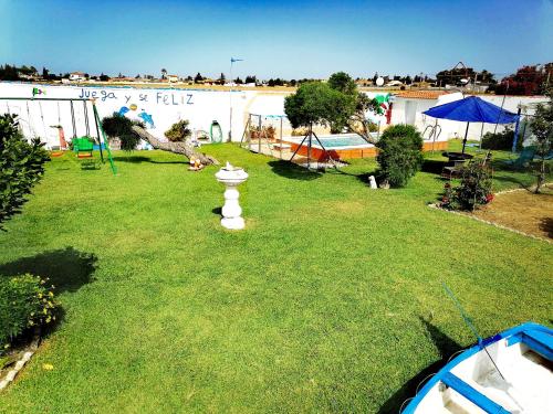 a yard with a fire hydrant in the grass at Mis Princesas en casa in Chiclana de la Frontera