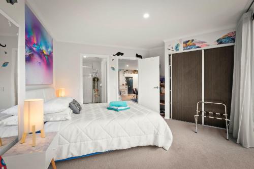 a white bedroom with a large bed and a mirror at Nelson Apartment, Relaxing, Hobart Escape in Sandy Bay