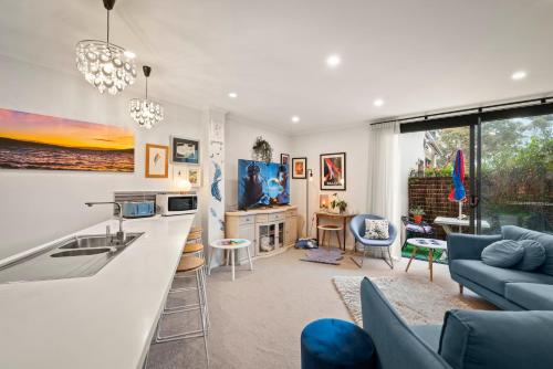 a kitchen and living room with a blue couch at Nelson Apartment, Relaxing, Hobart Escape in Sandy Bay