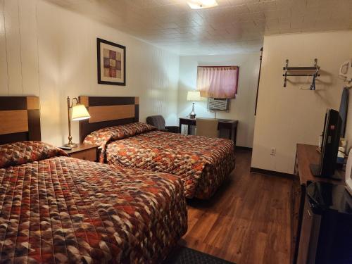 a hotel room with two beds and a television at Cortland Motel in Cortland