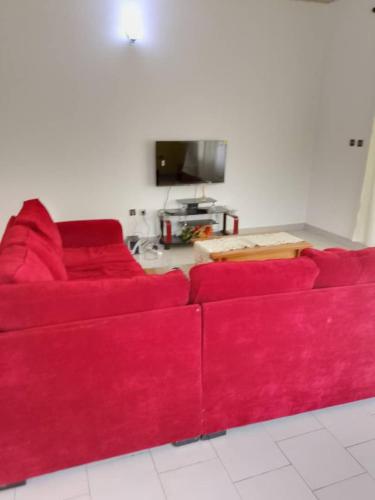 ein rotes Sofa im Wohnzimmer in der Unterkunft Residence Mindja in Kribi