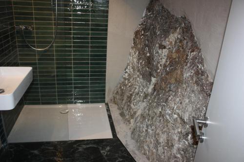 a bathroom with a sink and a large rock at Altstadt Apartment Melk in Melk