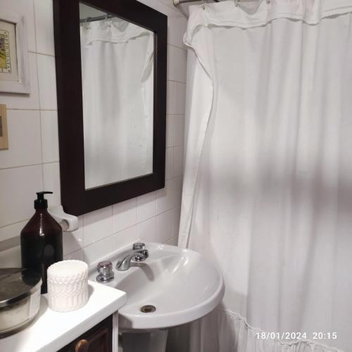 a bathroom with a sink and a white shower curtain at Espectacular salto centro in Salto