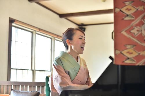 a woman sitting at a computer with her arms crossed at Petit Hotel Kanan in Chino