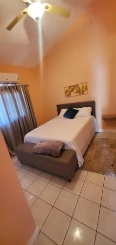 sypialnia z łóżkiem i wentylatorem sufitowym w obiekcie Finest Accommodation Caribbean Estate Lot 78 w mieście Portmore