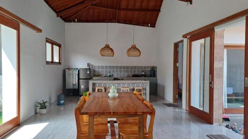 a kitchen with a wooden table and some chairs at Vera Koe in Kuta Lombok