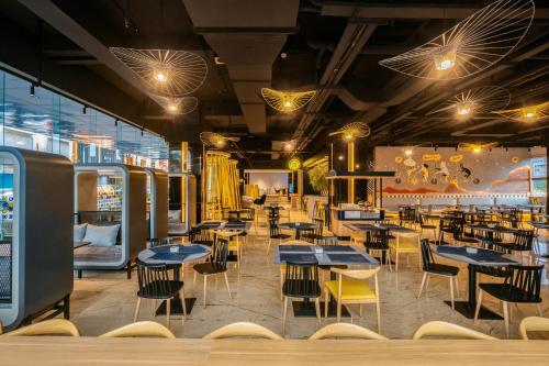 a restaurant with blue tables and yellow chairs at Yello Hotel Harbour Bay in Nagoya