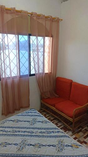 um quarto com uma cama, um sofá e uma janela em Suit Salinas/ semiamueblado em Salinas