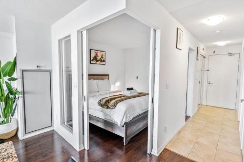 a bedroom with a bed in a room with white walls at Toronto downtown Fort York suites 1BDRM with parking in Toronto