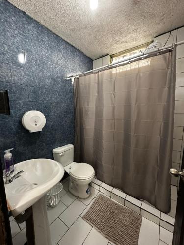 La salle de bains est pourvue de toilettes, d'un lavabo et d'une douche. dans l'établissement CASA MAGNOLIA, à Guatemala