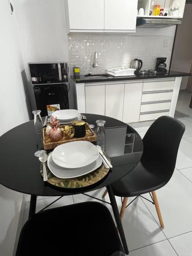 una mesa negra con platos en la cocina en Hermoso Departamento en Condominio Céntrico Con piscina! en Trinidad