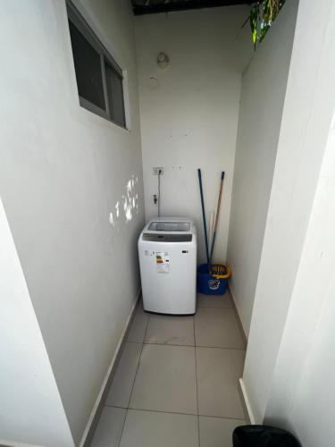 eine kleine Waschküche mit einer Waschmaschine in der Ecke in der Unterkunft Hermoso Departamento en Condominio Céntrico Con piscina! in Trinidad