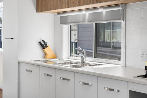 a white kitchen with a sink and a window at Waikerie Holiday Park in Waikerie