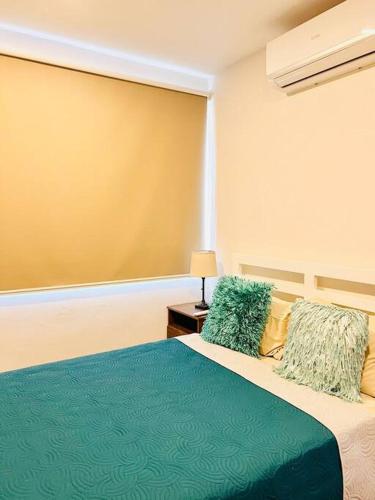 a bedroom with a bed with a blue blanket and pillows at Casa Bellota in Marbella