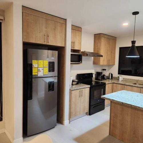 a kitchen with wooden cabinets and a stainless steel refrigerator at Casa Bellota in Marbella