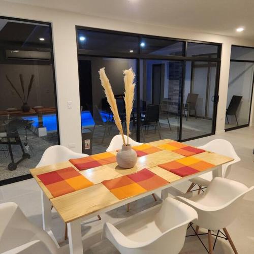 a dining room table with white chairs and a vase on it at Casa Bellota in Marbella