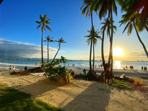 a group of people on a beach with palm trees at Urban Boutique Hotel in Boracay