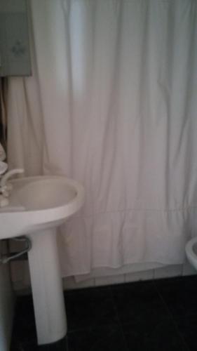 a bathroom with a sink and a white shower curtain at Guidi in Mar del Plata
