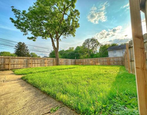 a yard with a fence and a tree at Modern Luxe 3BR/1BA with Bar in Columbus